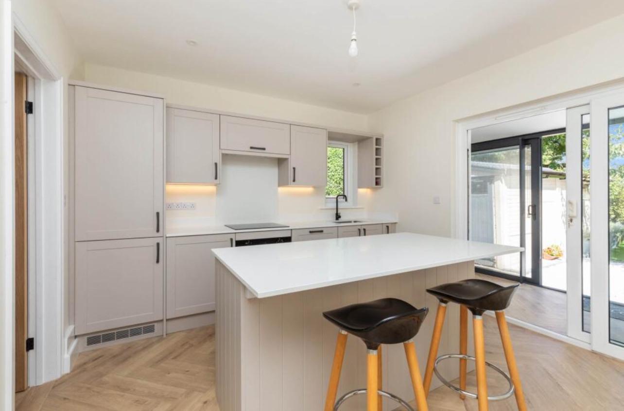 Finished kitchen with a pale island and glazed doors